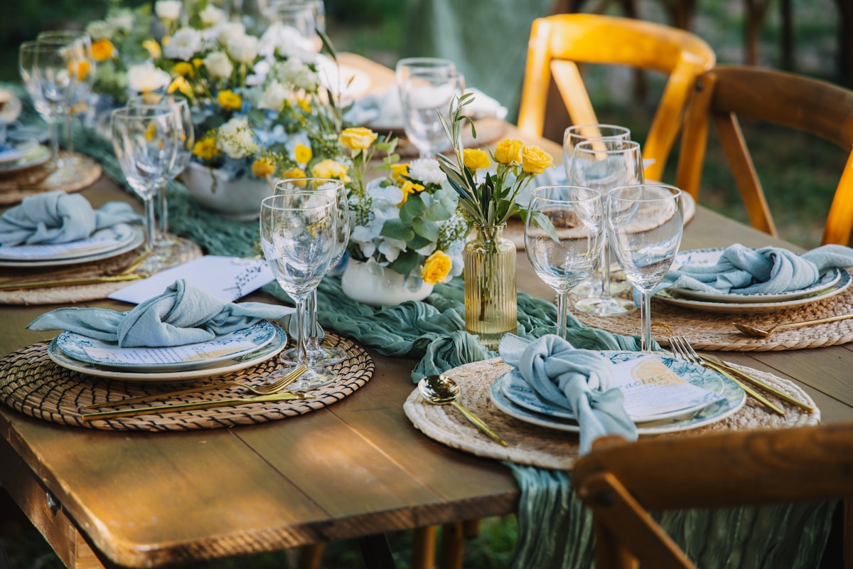 Elegantly set outdoor dining table with floral arrangements for a wedding reception